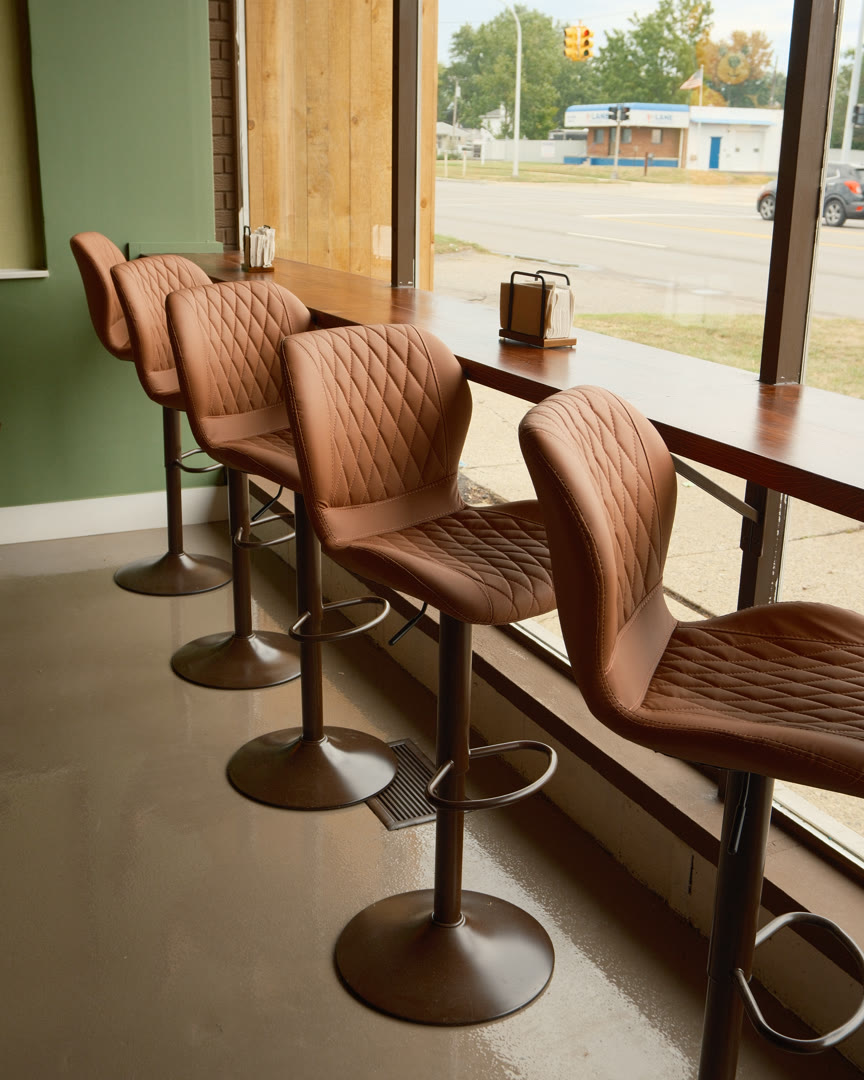 The window bar at The Snug Mug, with leather stools looking out over Middlebelt Road